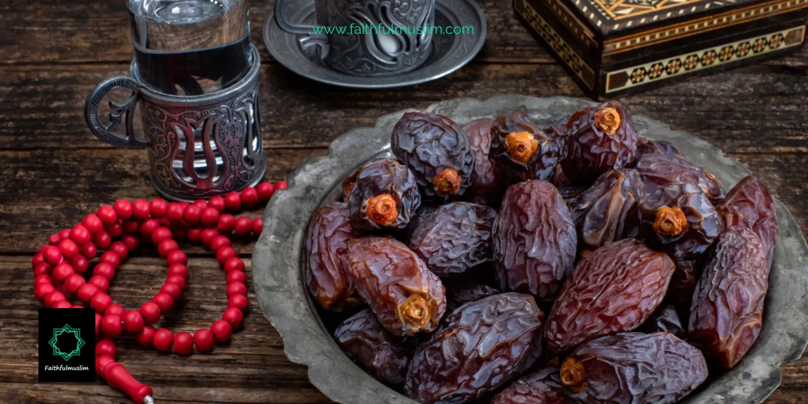 Red prayer beads, water filled cups and a bowl of dates are kept on a wooden table for iftar in Ramadan to break fast.